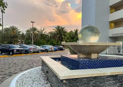 a fountain in front of a parking lot with cars at Bella Vista - Water views Pool and Parking in Miami Beach