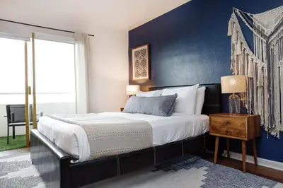 a bedroom with a large bed with a blue wall at Bella Vista - Water views Pool and Parking in Miami Beach