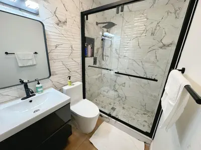 a bathroom with a shower and a toilet and a sink at Amazing 3-bedroom modern home in Coral Gables area in Miami
