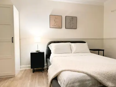a bedroom with a bed and two pictures on the wall at Amazing 3-bedroom modern home in Coral Gables area in Miami