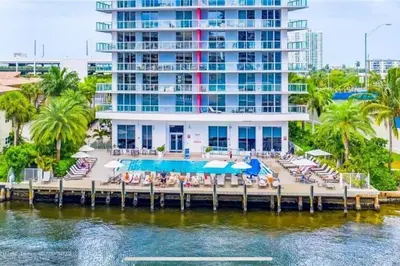 a resort with a dock with chairs and a pool at Miami Beach Luxury Apt, Ocean Views, Full Kitchen -A in Hallandale Beach