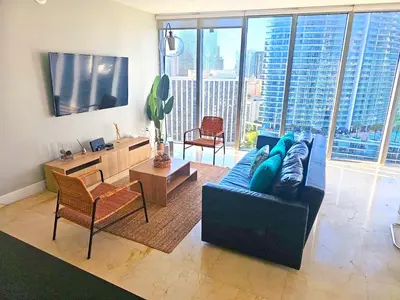 a living room with a blue couch and a large window at Wonderful 2 BR Condo Icon Brickell With Pool in Miami