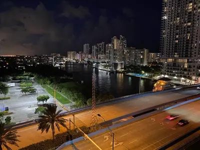 a view of a city at night with a river at Just Minutes from the Beach, 2 Full Bed Studio in Hallandale Beach