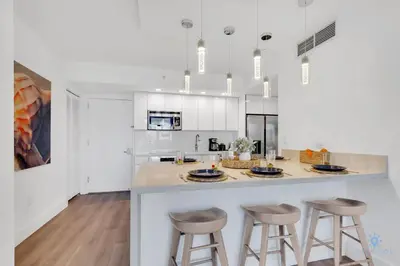 a kitchen with a large island with bar stools at Modern Resort with Balcony - Pool - Gym in Hallandale Beach