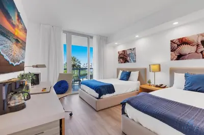 a hotel room with two beds and a balcony at Modern Resort with Balcony - Pool - Gym in Hallandale Beach