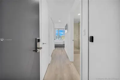 a hallway with white walls and a wooden floor at Modern Beach Studio, 2 Full Beds, Prime Location in Hallandale Beach