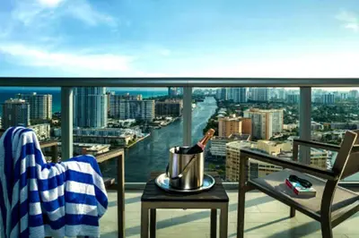 a balcony with a table and a view of a city at Modern Beach Studio, 2 Full Beds, Prime Location in Hallandale Beach