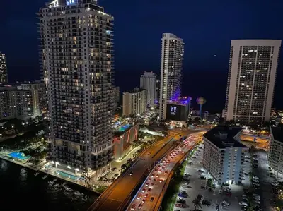 a city skyline with tall buildings and a street at night at Stylish BeachWalk Studio, Sleep 4 Comfortably in Hallandale Beach