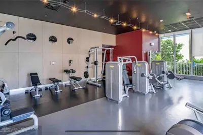 a gym with several treadmills and machines at Walk to the Waves, 2 Full Bed Beach Studio Stay in Hallandale Beach