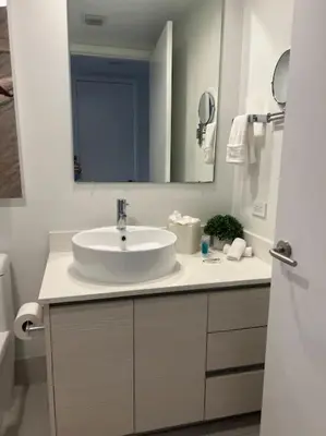 a white bathroom with a sink and a mirror at Studio BeachWalk, Ocean Breeze & 2 Full Beds in Hallandale Beach