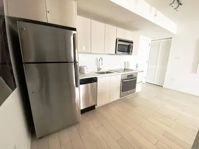 a large kitchen with a stainless steel refrigerator at Elegance in Miami Beach, Kitchen & Views -A in Hallandale Beach