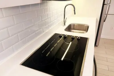 a kitchen with a sink and a stove top oven at Luxe Beachfront Living - Premium Comfort -A in Hallandale Beach